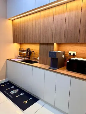 a kitchen with a counter with a sink and a microwave at MU Homestay in Simpang Ampat