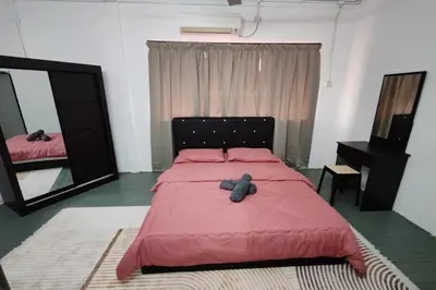a bedroom with a bed with a red comforter at DRH Villa in Ipoh