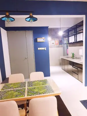 a dining room with a table and chairs and a kitchen at HomeStay Amer in Ipoh