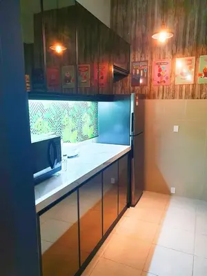 a kitchen with a counter top and a refrigerator at HomeStay Amer in Ipoh
