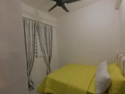 a bedroom with a yellow bed and a window at HomeStay Amer in Ipoh