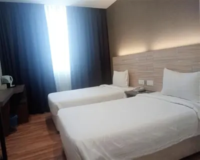 a hotel room with two beds and a window at U Design Hotel Bukit Mertajam in Bukit Mertajam