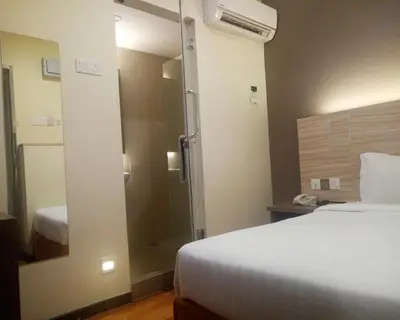 a hotel room with a bed and a shower at U Design Hotel Bukit Mertajam in Bukit Mertajam