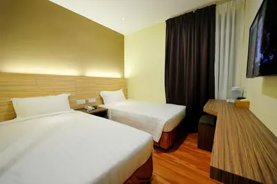 a hotel room with two beds and a flat screen tv at U Design Hotel Bukit Mertajam in Bukit Mertajam
