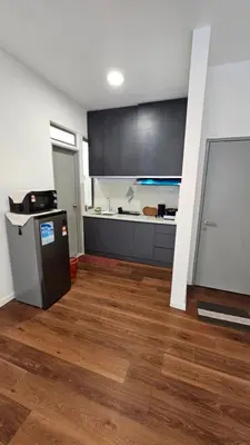 a kitchen with black cabinets and a wooden floor at CAMERON HIGHLAND BRINCHANG KEA FARM Homestay By Dcozy 6-7pax in Brinchang