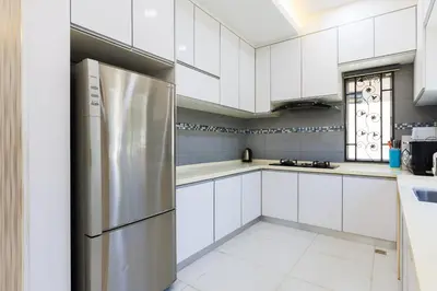 a kitchen with white cabinets and a stainless steel refrigerator at Comfy Bungalow Family House Pg Hill & Kek Lok Si in Ayer Itam