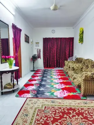 a living room with a couch and a rug at Homestay Kak Kiah Taiping in Taiping