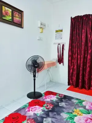 a room with a fan and a rug on the floor at Homestay Kak Kiah Taiping in Taiping