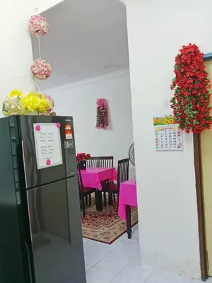 a dining room with a table and a refrigerator at Homestay Kak Kiah Taiping in Taiping