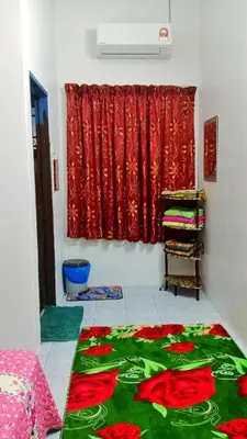 a room with a bed and a red curtain at Homestay Kak Kiah Taiping in Taiping