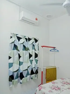a bedroom with a colorful patterned curtain and a bed at Homestay Kak Kiah Taiping in Taiping