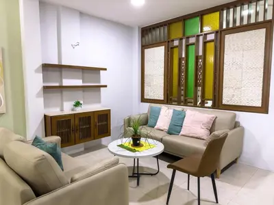 a living room with two couches and a table at Gracious Green Gurney in George Town