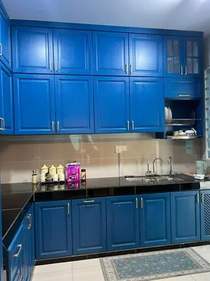 a blue kitchen with black counters and blue cabinets at Singgah homestay 2 in Sitiawan