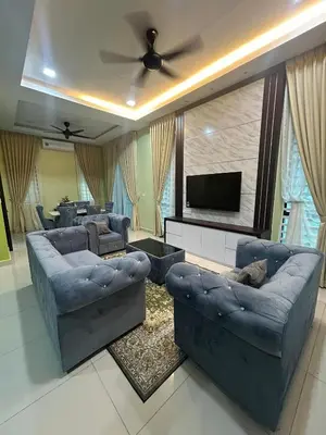 a living room with couches and a flat screen tv at Singgah homestay 2 in Sitiawan