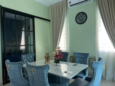 a dining room with a white table and blue chairs at Singgah homestay 2 in Sitiawan