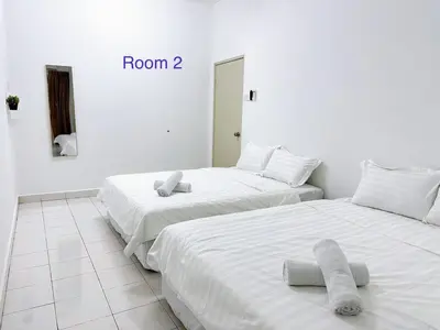 two beds in a white room with towels on them at POP Stay \u6cca\u5c45 Sungai Bakap Jawi in Kampong Gurun