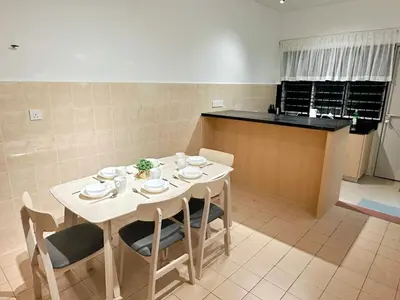 a kitchen with a white table with chairs and a counter at POP Stay \u6cca\u5c45 Sungai Bakap Jawi in Kampong Gurun