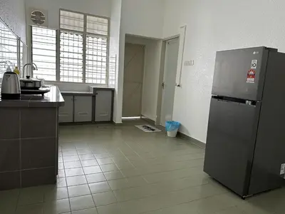 a kitchen with a stainless steel refrigerator in a room at Leisure Homestay in Nibung Tebal