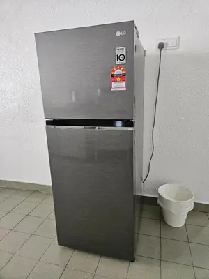 a stainless steel refrigerator in a room with a toilet at Leisure Homestay in Nibung Tebal