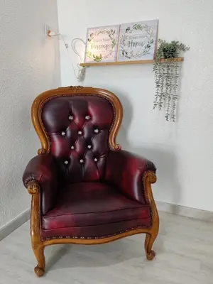 a red leather chair sitting in a room at Leisure Homestay in Nibung Tebal