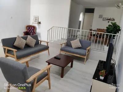 a living room with two couches and a tv at Leisure Homestay in Nibung Tebal