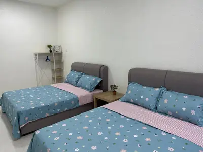 a room with two beds with blue and pink sheets at Leisure Homestay in Nibung Tebal