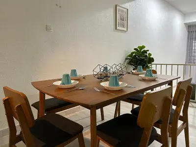 a dining room table with chairs and a wooden tableablish at Leisure Homestay in Nibung Tebal
