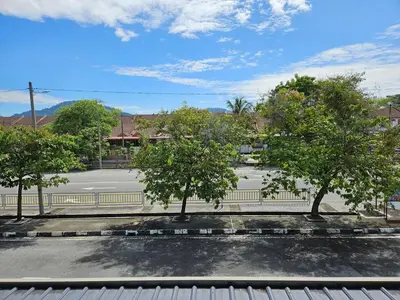 two trees in a parking lot with a street at Leisure Homestay BM in Bukit Mertajam