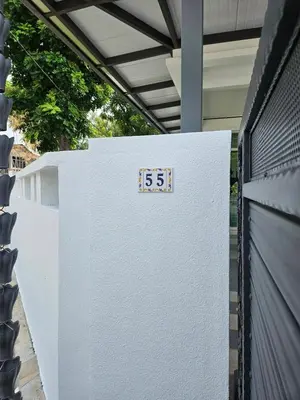 a white refrigerator with a sign on it next to a fence at Leisure Homestay BM in Bukit Mertajam