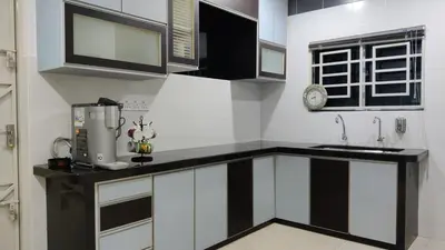 a kitchen with black and white cabinets and a sink at Leisure Homestay BM in Bukit Mertajam