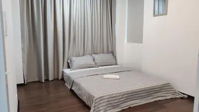 a bedroom with a bed with a white blanket at Leisure Homestay BM in Bukit Mertajam