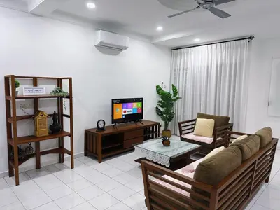 a living room with a couch and a tv at Maple Home BM in Bukit Mertajam