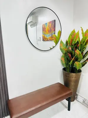 a mirror hanging on a wall next to a bench at Effa Homestay in Sungai Petani