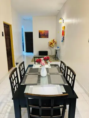 a dining room with a black table and chairs at Effa Homestay in Sungai Petani