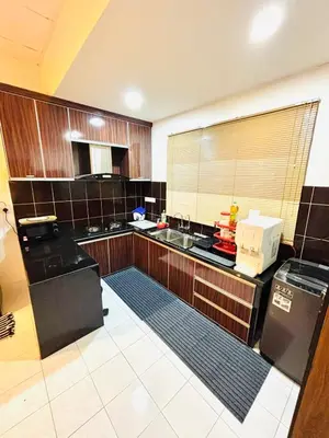 a large kitchen with wooden cabinets and a counter at Effa Homestay in Sungai Petani