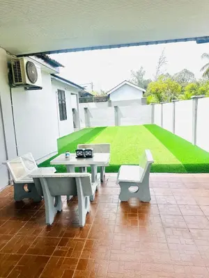 a patio with a table and chairs and a lawn at Effa Homestay in Sungai Petani