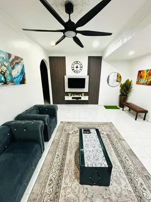 a living room with a couch and a ceiling fan at Effa Homestay in Sungai Petani
