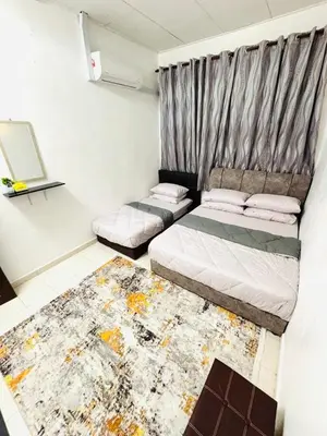 a bedroom with two beds and a rug at Effa Homestay in Sungai Petani
