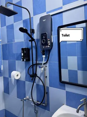 a bathroom with a toilet and a phone on the wall at Pantai Remis 116 Minsu Homestay in Pantai Remis