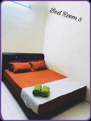 a bed with two green towels on top of it at Nizaman's Homestay Gerik in Gerik