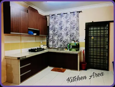 a kitchen with wooden cabinets and a window in a room at Nizaman's Homestay Gerik in Gerik