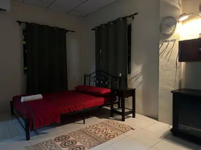 a bedroom with a bed with a red blanket at Homestay Teluk Bayu in Sungai Petani