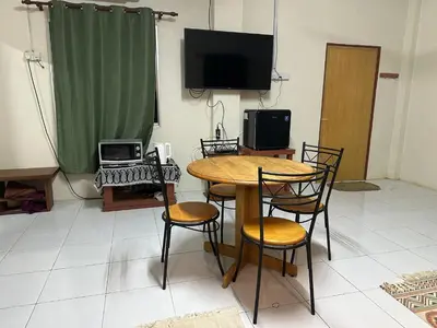 a room with a table and chairs and a television at Homestay Teluk Bayu in Sungai Petani