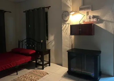 a room with a bed and a tv and a lamp at Homestay Teluk Bayu in Sungai Petani