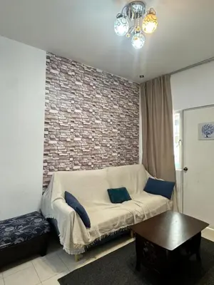 a living room with a couch and a brick wall at AYAAN HOMESTAY Tanah Rata with Netflix in Tanah Rata