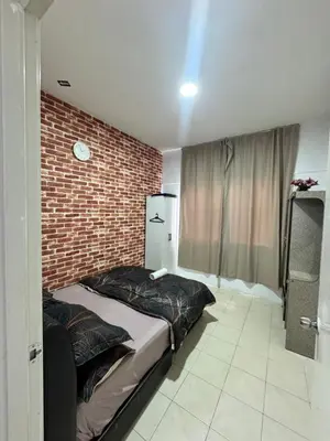 a bedroom with a bed and a brick wall at AYAAN HOMESTAY Tanah Rata with Netflix in Tanah Rata