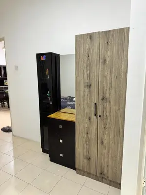 a room with a wooden cabinet next to a desk at AYAAN HOMESTAY Tanah Rata with Netflix in Tanah Rata