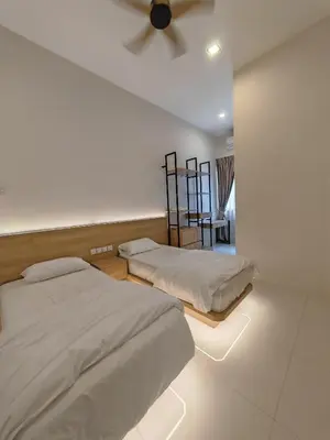 a bedroom with two beds and a ceiling fan at Ipoh M Villa in Ipoh