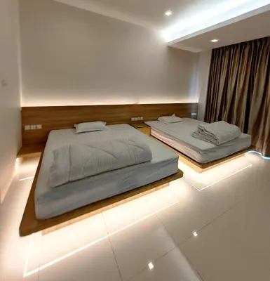 two beds in a bedroom with lights on the floor at Ipoh M Villa in Ipoh
