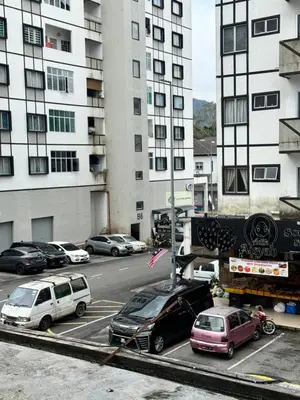 a parking lot with cars parked in front of a building at AYAAN Prima Homestay 1 with Netflix in Tanah Rata